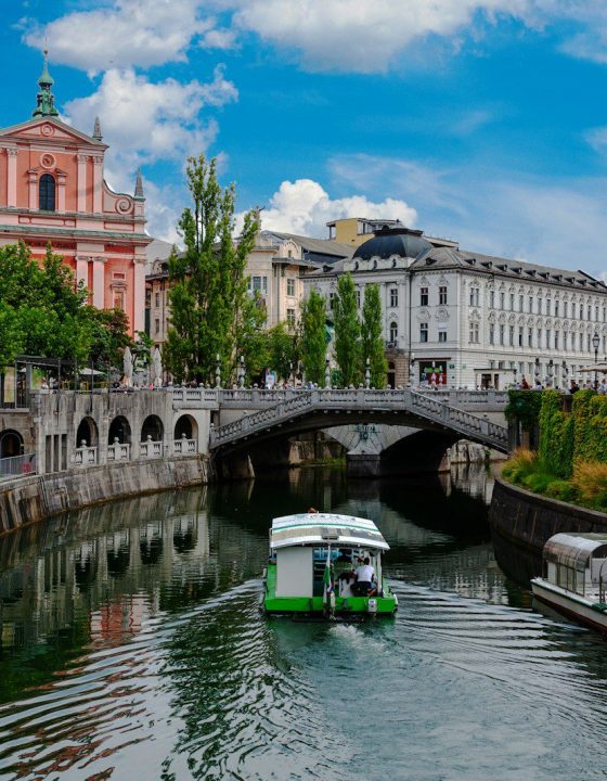 green boat on river near bridge during daytime